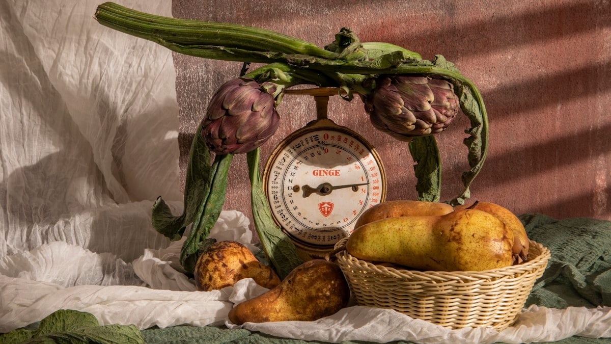 Vegetables are displayed with an antique scale.